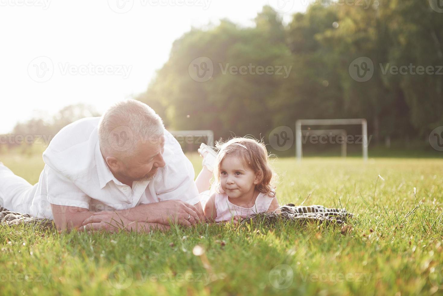 Portrait of grandfather with granddaughter, relaxing together in the park photo