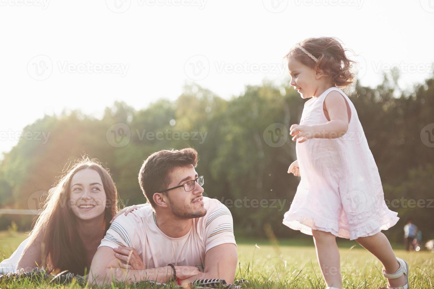 familia feliz, padre de madre e hija de bebé en la naturaleza al atardecer foto