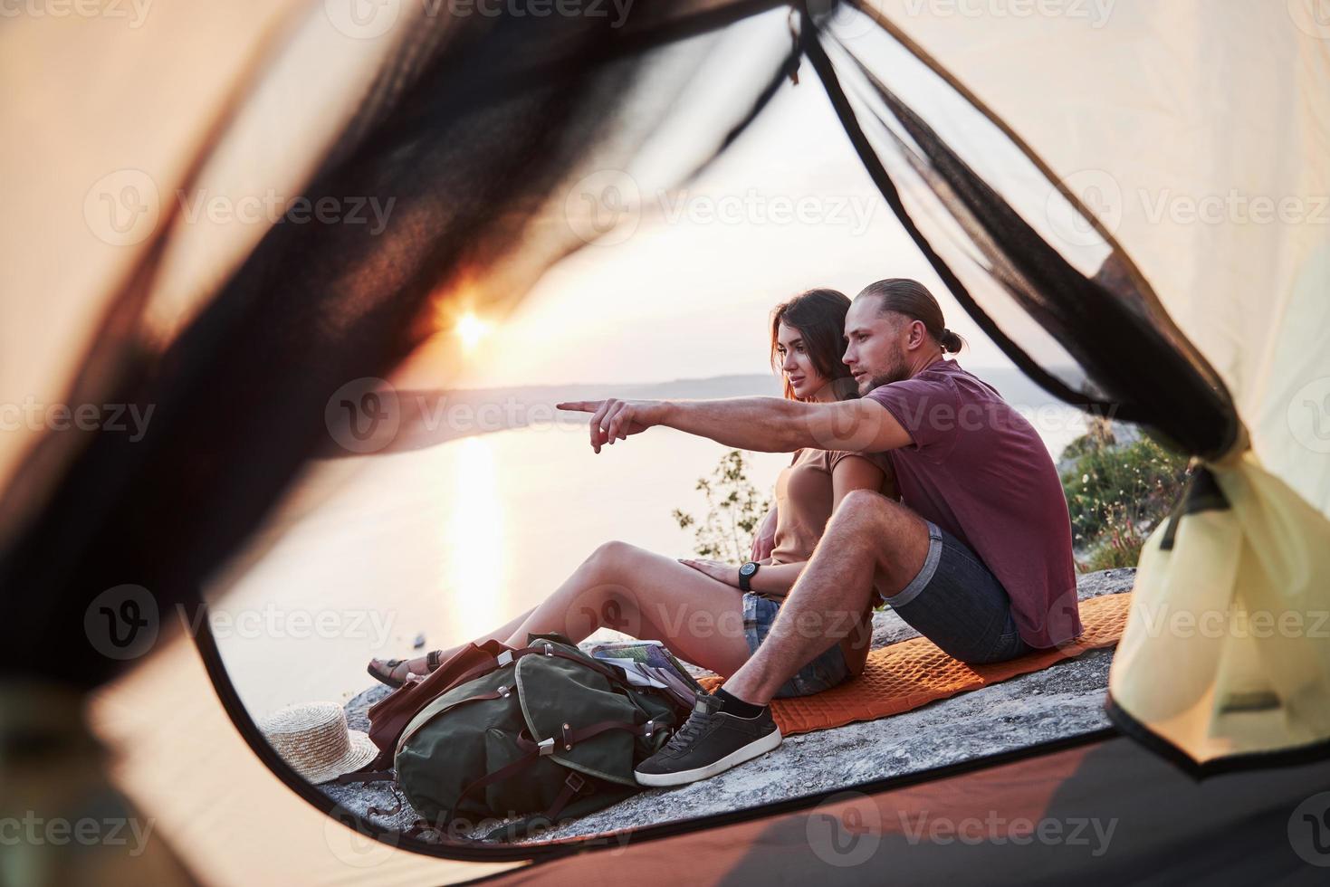 View from tent of couple lying a view of lake during hiking trip. avel Lifestyle concept adventure vacations outdoor photo