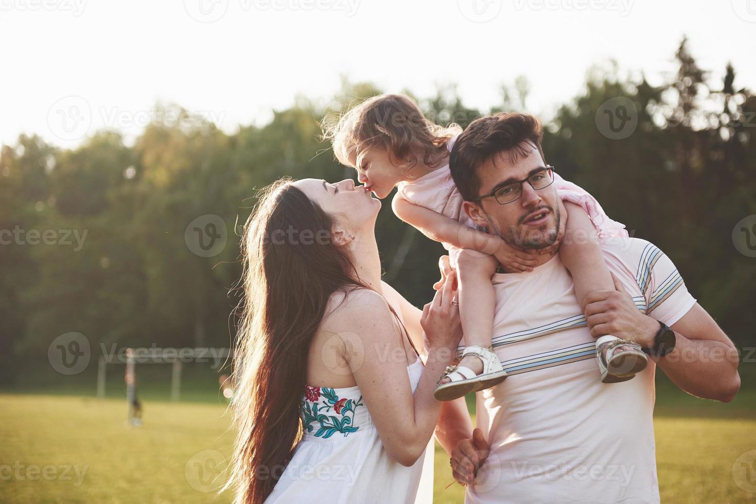 Happy family, father of mother and daughter of baby in the nature at sunset photo