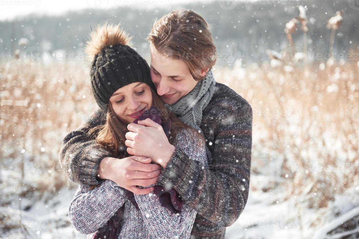 christmas happy couple in love embrace in snowy winter cold forest, copy space, new year party celebration, holiday and vacation, travel, love and relations photo