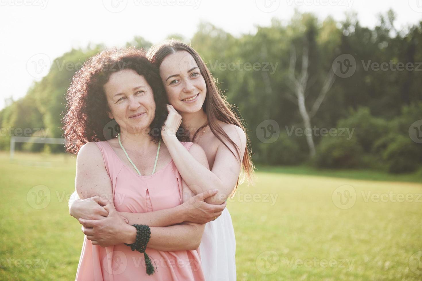 Love is mother and daughter. An old woman and her adult child in the park. photo