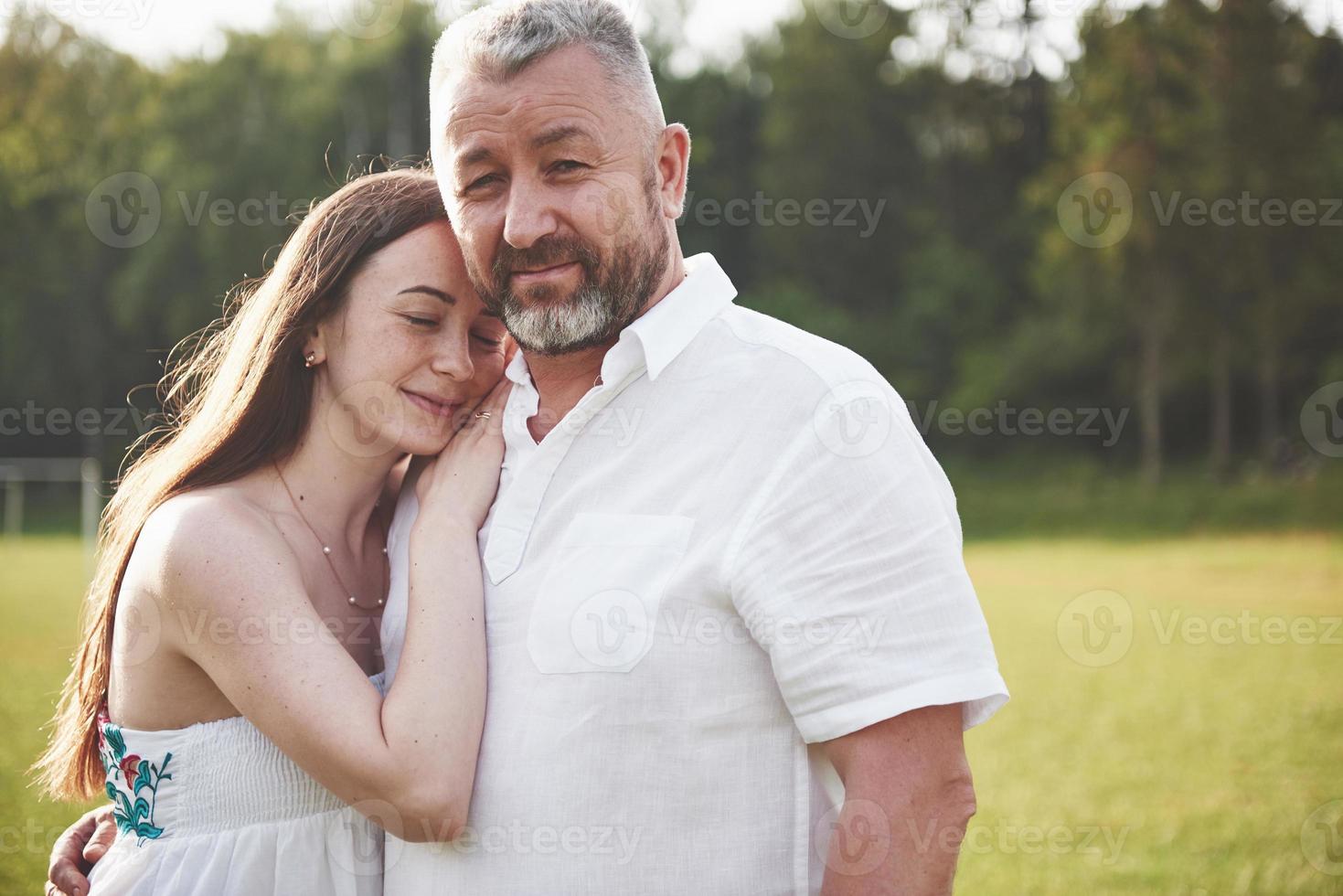 An elderly man hugged his adult daughter outdoors photo