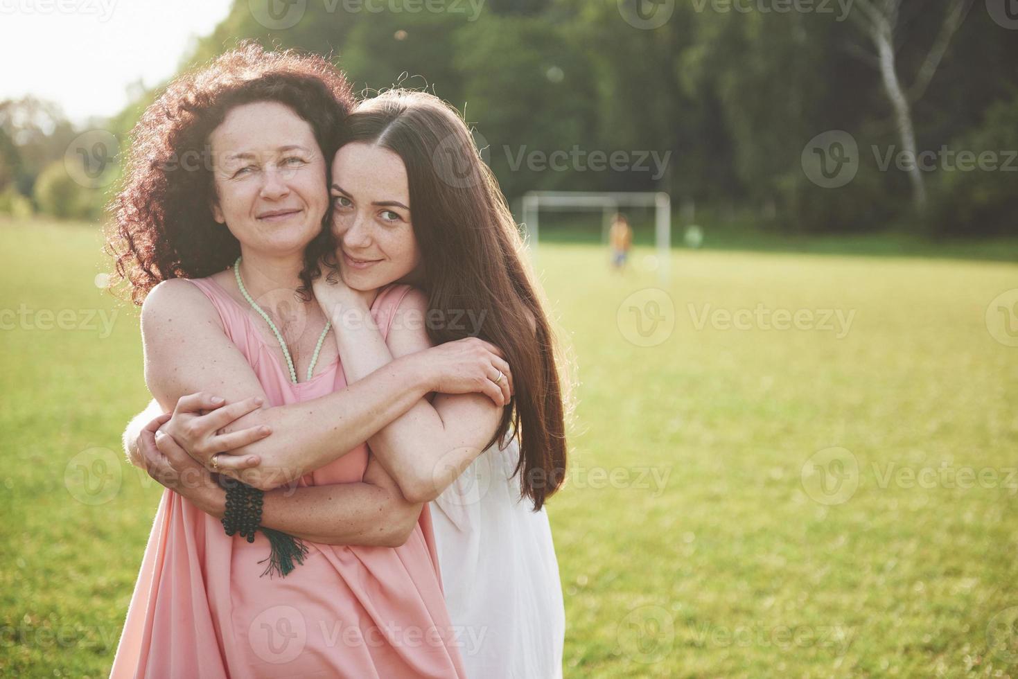 Love is mother and daughter. An old woman and her adult child in the park. photo