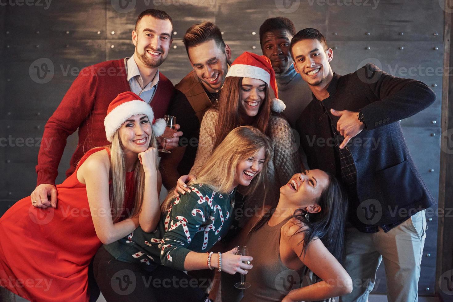 el nuevo año está llegando. Grupo de alegres jóvenes multiétnicos con gorro de Papá Noel en la fiesta, posando concepto de gente de estilo de vida emocional foto