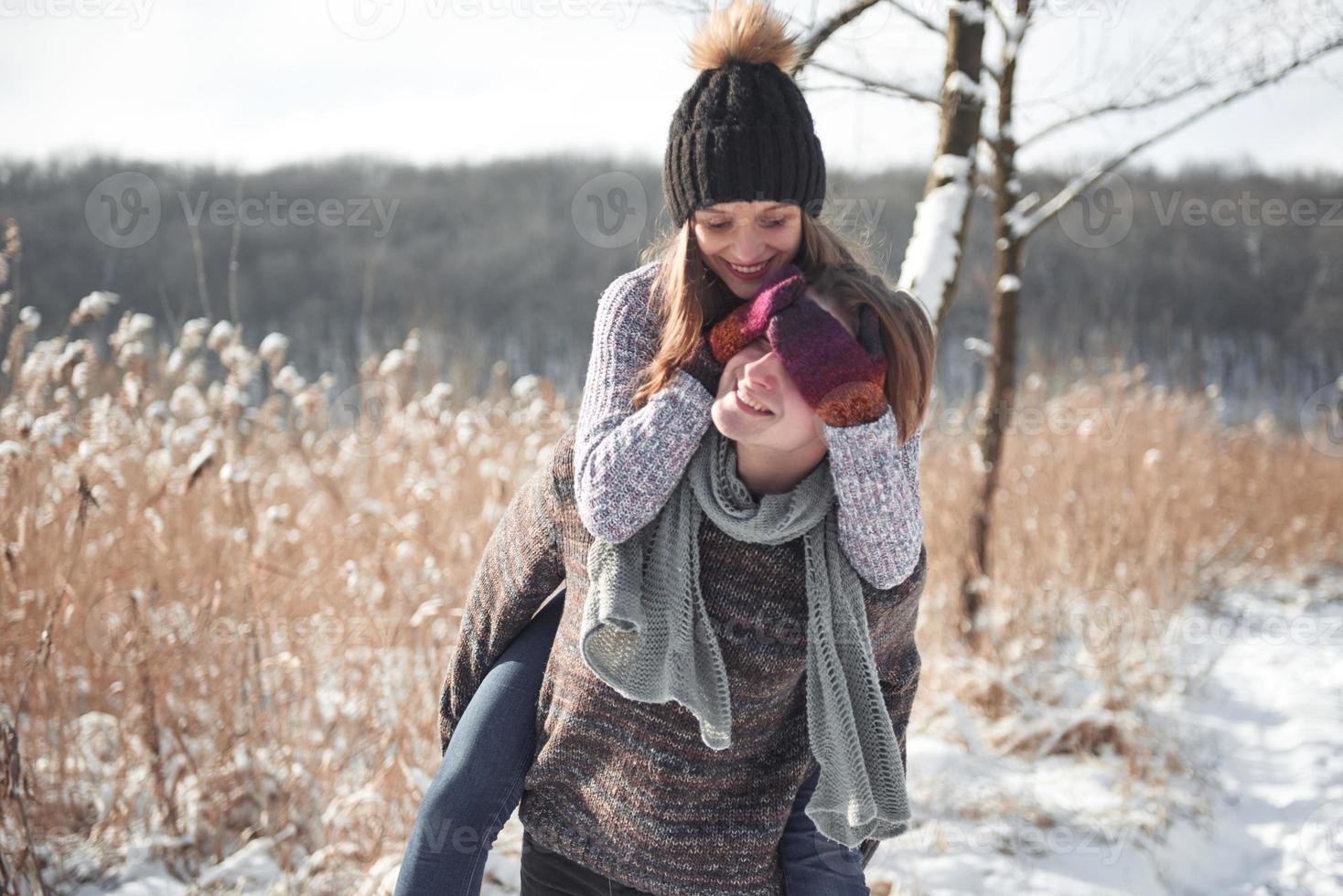 Feliz pareja joven se divierte en la nieve fresca en un hermoso día soleado de invierno de vacaciones foto