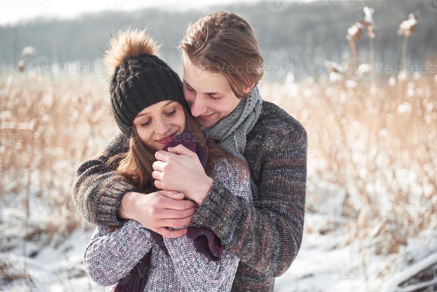 Happy young couple has fun on fresh snow at beautiful winter sunny day on vacation photo