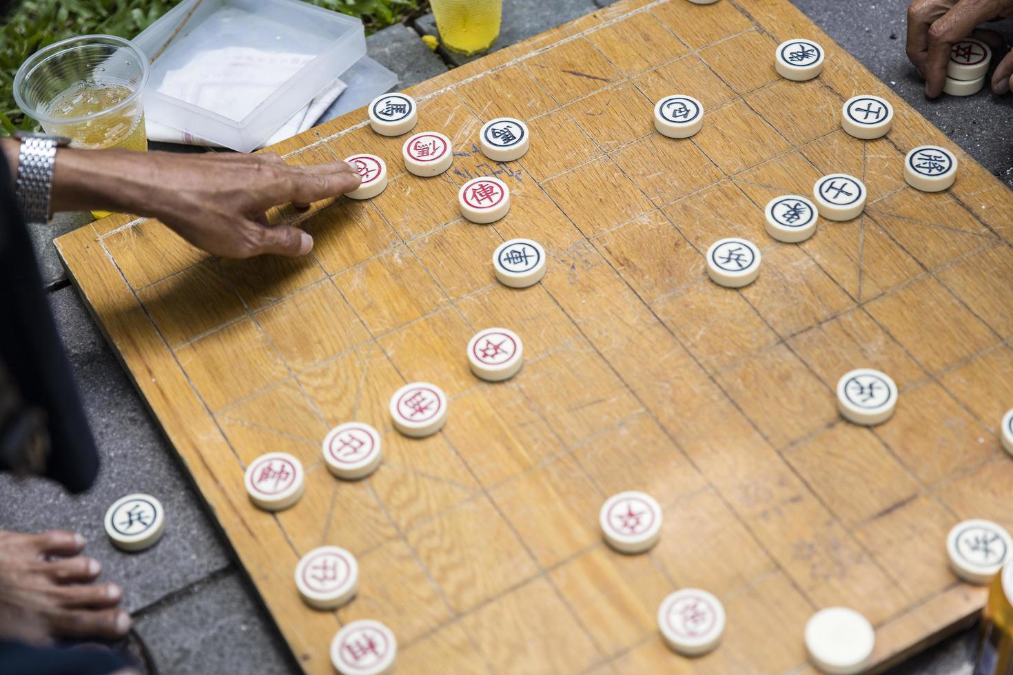 Ho chi minh, vietnam, 22 de febrero de 2017 - hombre no identificado jugando al ajedrez chino tradicional en la acera de ho chi minh en vietnam. es uno de los juegos de mesa más populares de China. foto