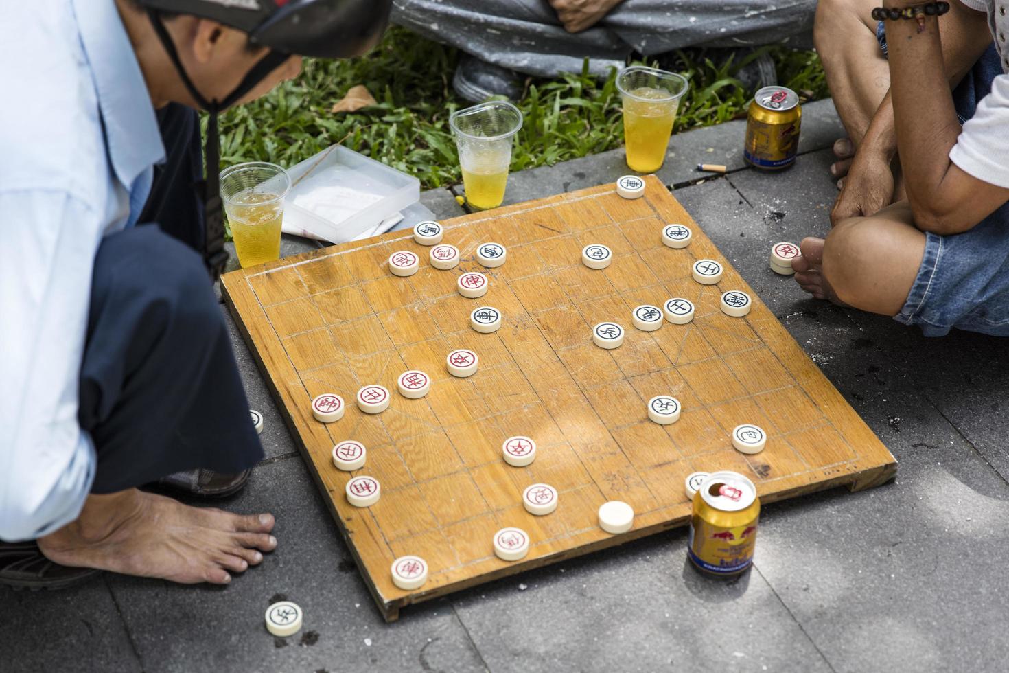 Ho chi minh, vietnam, 22 de febrero de 2017 - hombre no identificado jugando al ajedrez chino tradicional en la acera de ho chi minh en vietnam. es uno de los juegos de mesa más populares de China. foto