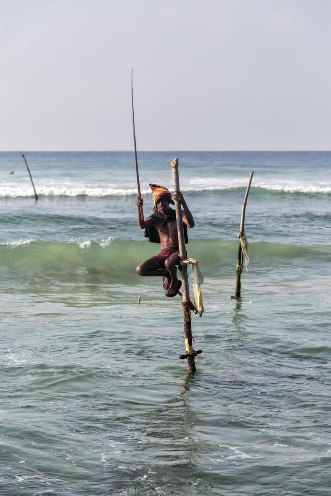 UNAWATUNA, SRI LANKA, JANUARY 25, 2014 - Unidentified stilt fishermen at Unawatuna, Sri Lanka. Stilt fishing is special to Galle district and thereare about 500 fishing families in the coastal belt. photo