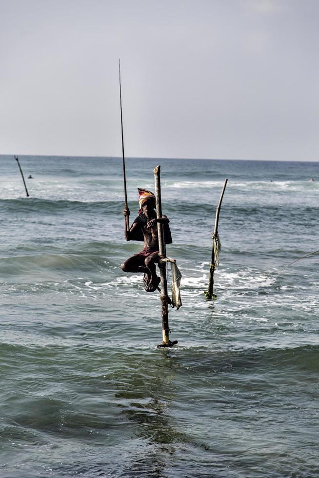 UNAWATUNA, SRI LANKA, JANUARY 25, 2014 - Unidentified stilt fishermen at Unawatuna, Sri Lanka. Stilt fishing is special to Galle district and thereare about 500 fishing families in the coastal belt. photo