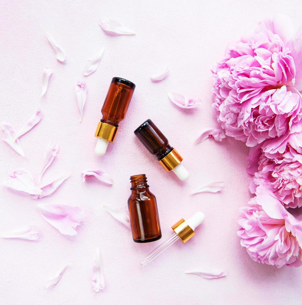 Aromatherapy essentials oils and pink peonies photo