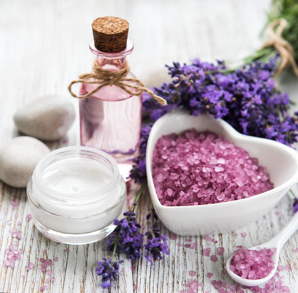Heart-shaped bowl with sea salt, oil  and fresh lavender flowers photo