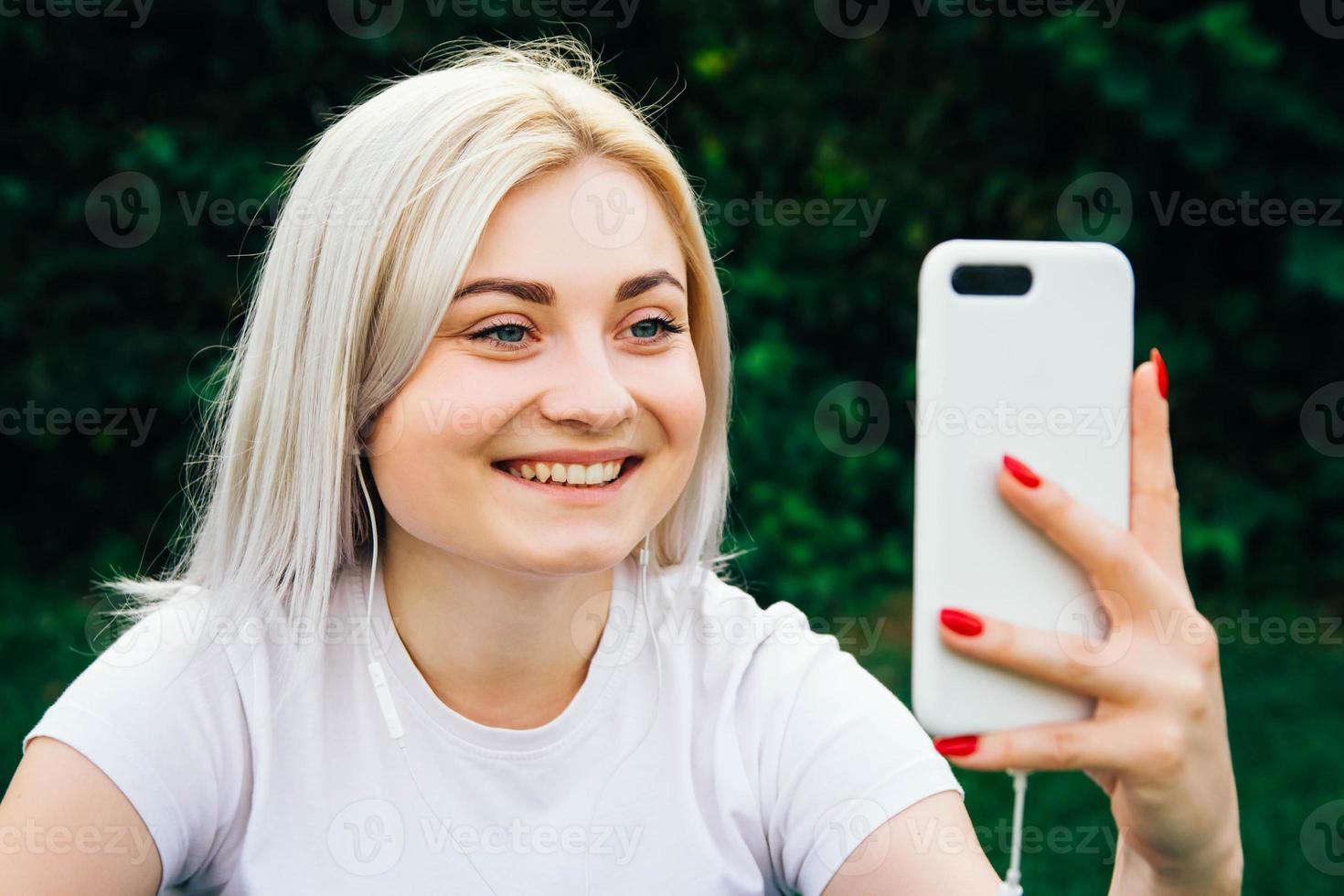 Woman in headphones and smartphone on green background photo