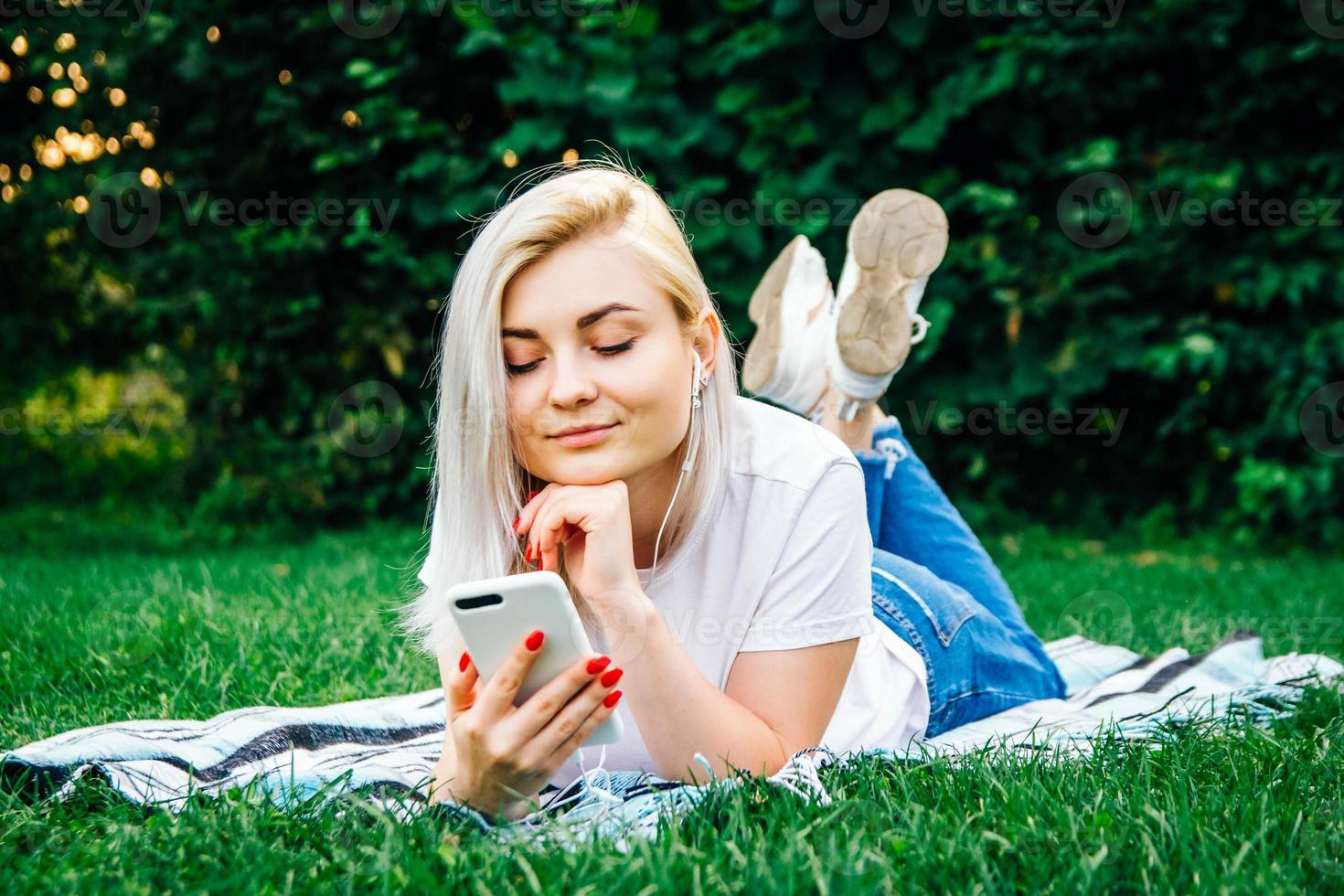Woman in headphones and smartphone in hands listens to music photo