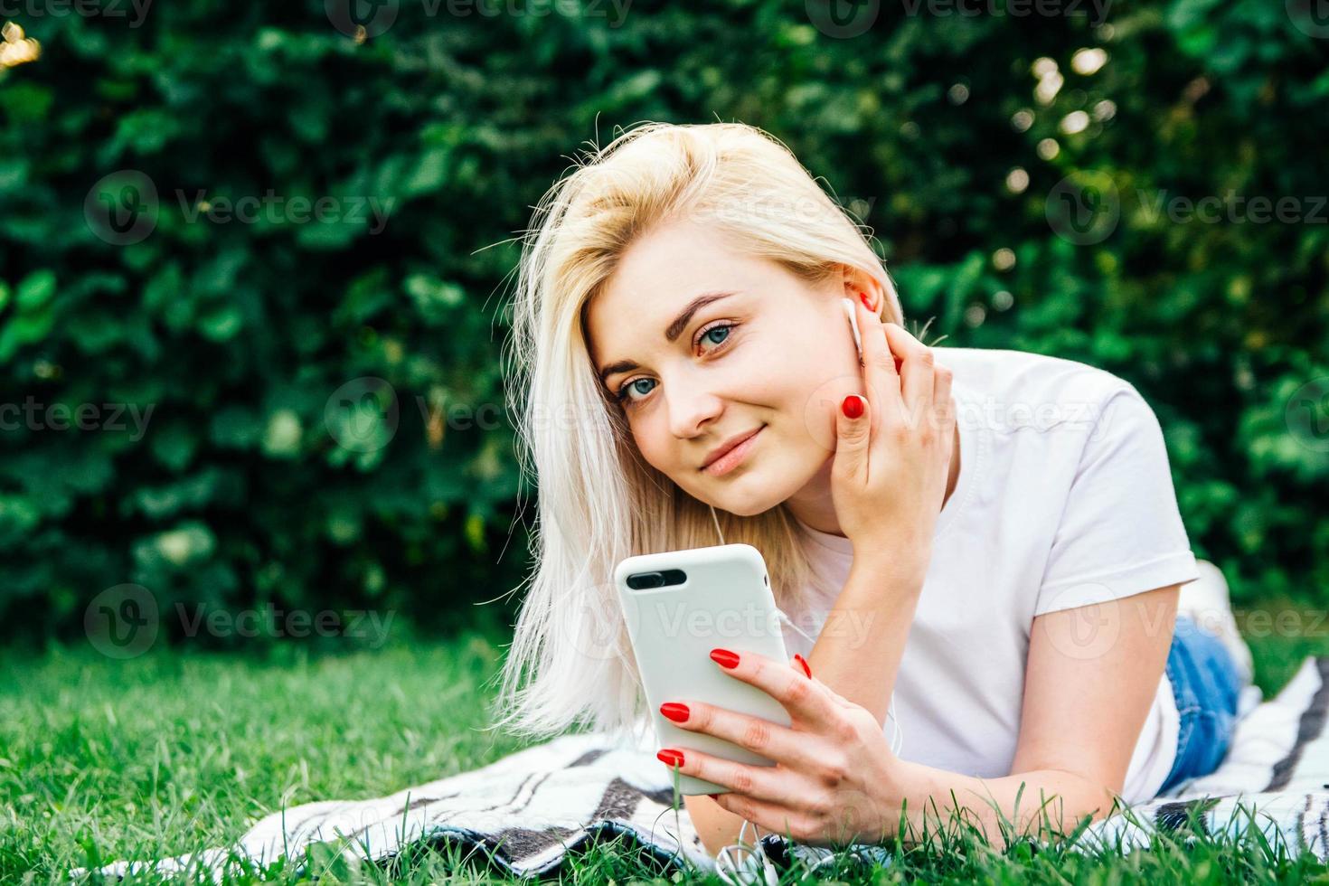 mujer en auriculares y smartphone en manos escucha música foto