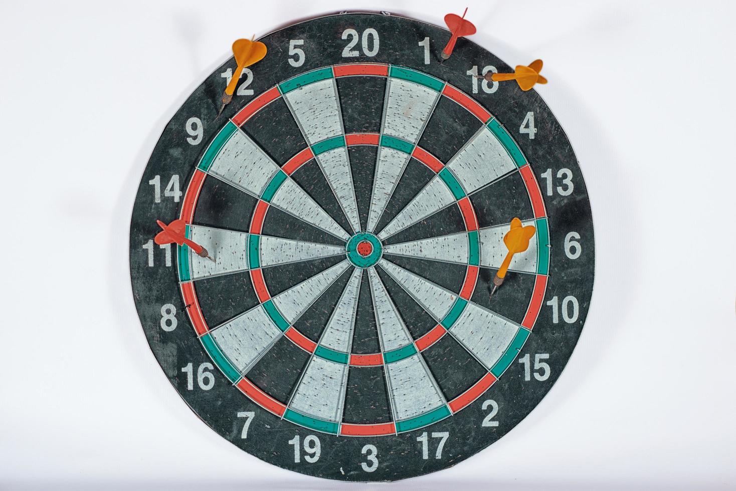 old shabby dartboard with darts on white background photo
