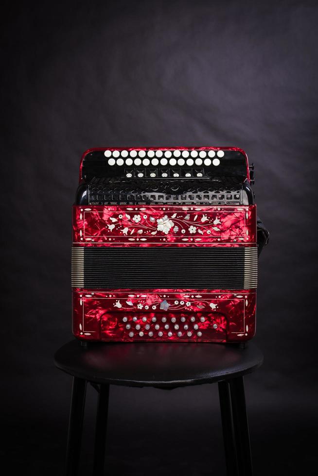 Russian folk instruments.Red bayan on a black background.Russian accordion photo