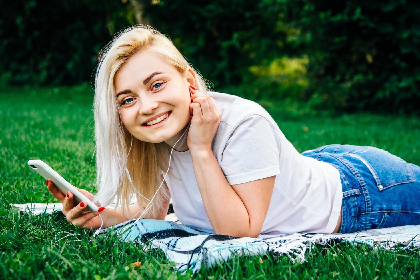 Woman in headphones and smartphone in hands listens to music photo