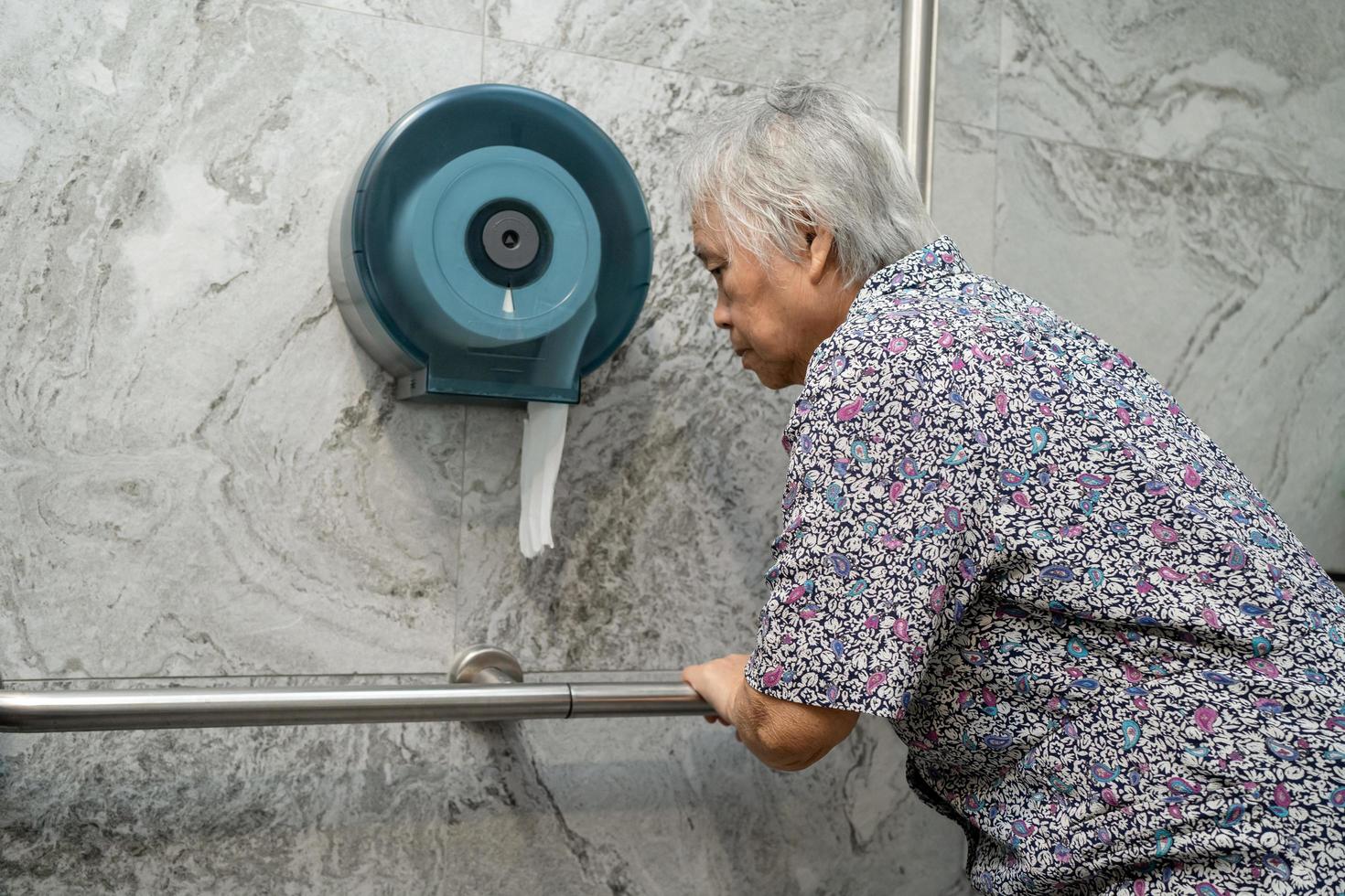 Asia mayor o anciana anciana mujer paciente uso inodoro baño manejar seguridad en enfermería hospital, concepto médico fuerte saludable. foto