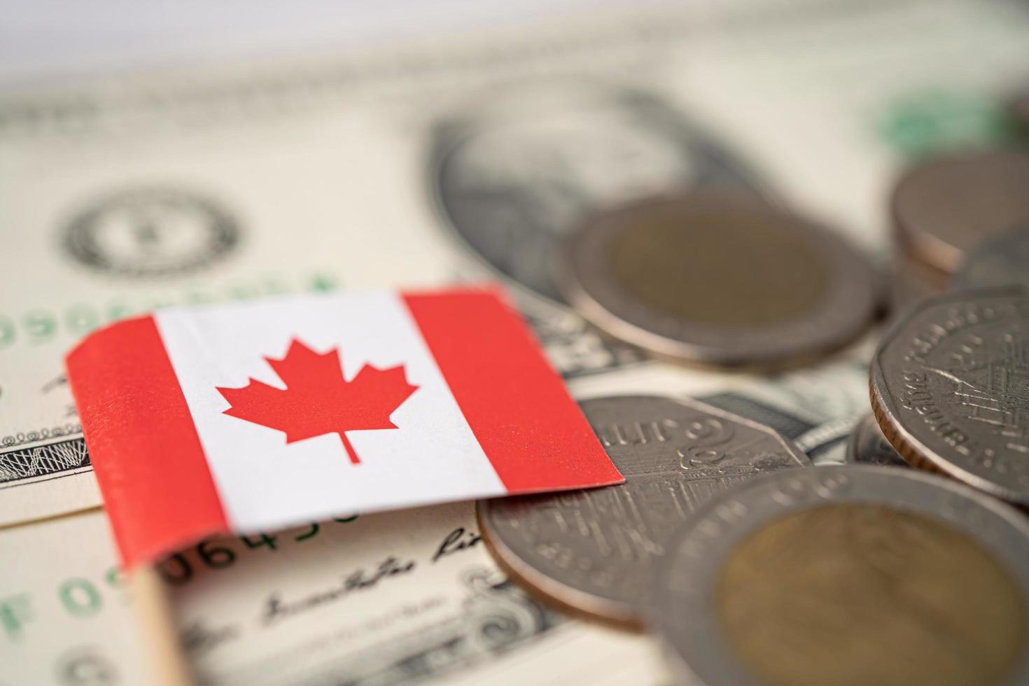 Canada flag on coins and banknotes background, finance and accounting, banking concept. photo