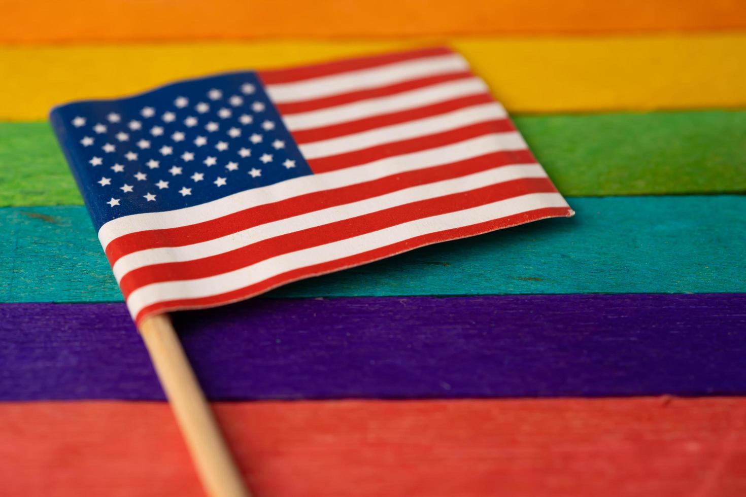 America USA flag on rainbow background symbol of LGBT gay pride month  social movement rainbow flag is a symbol of lesbian, gay, bisexual, transgender, human rights, tolerance and peace. photo