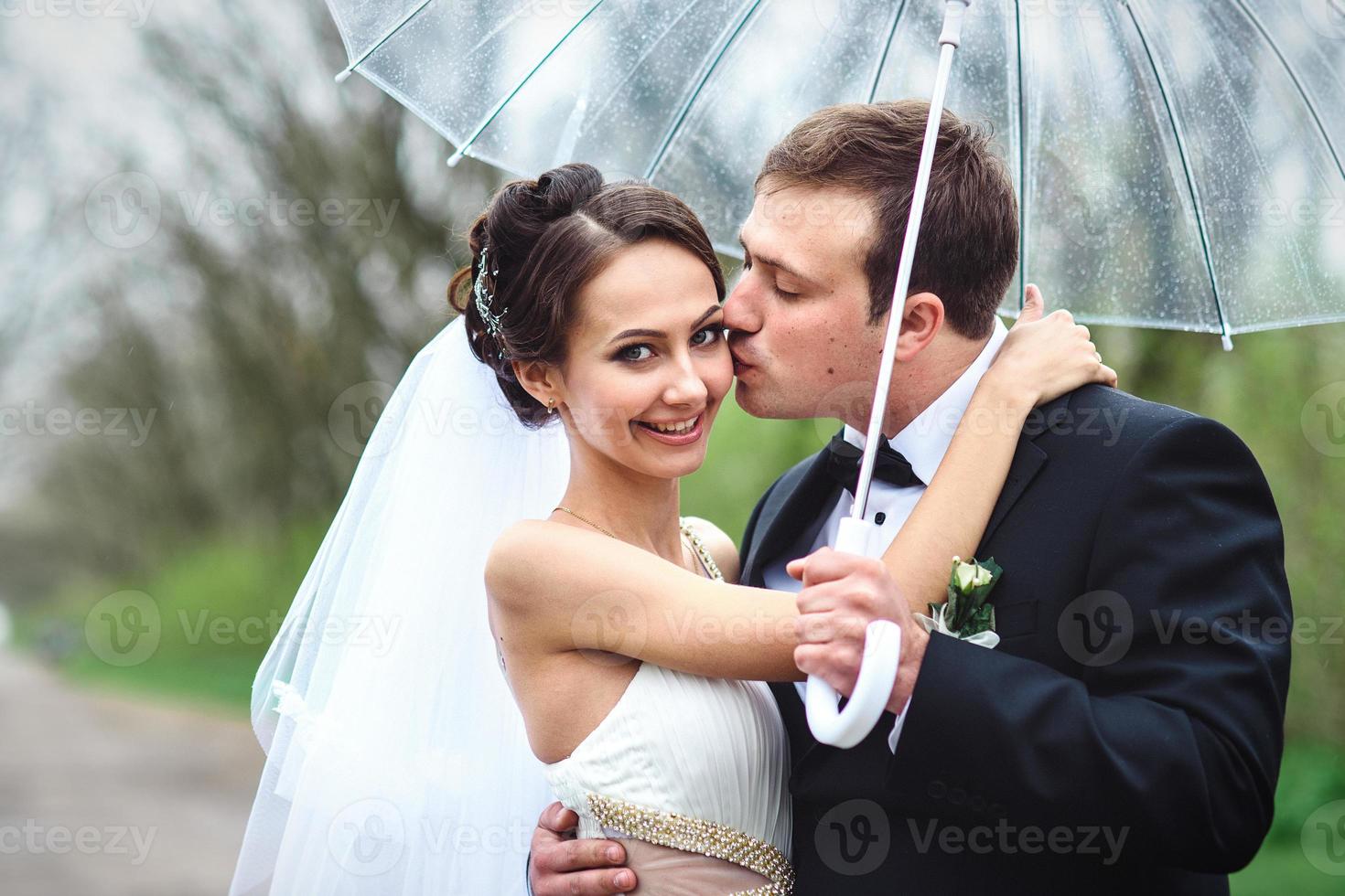 bride and groom on a rainy wedding day walking photo