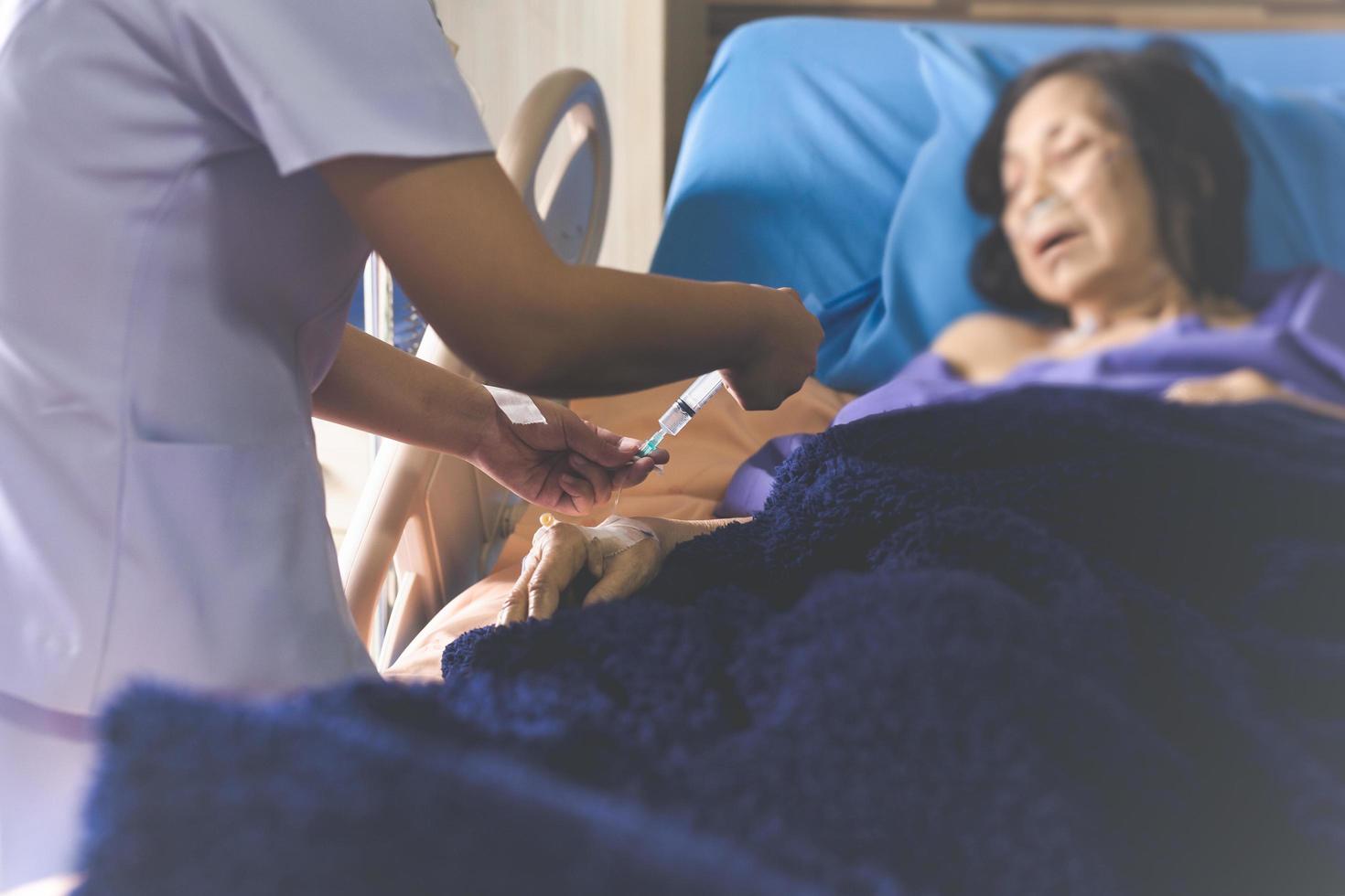 Nurse giving an injection to a patient at the hospital. photo