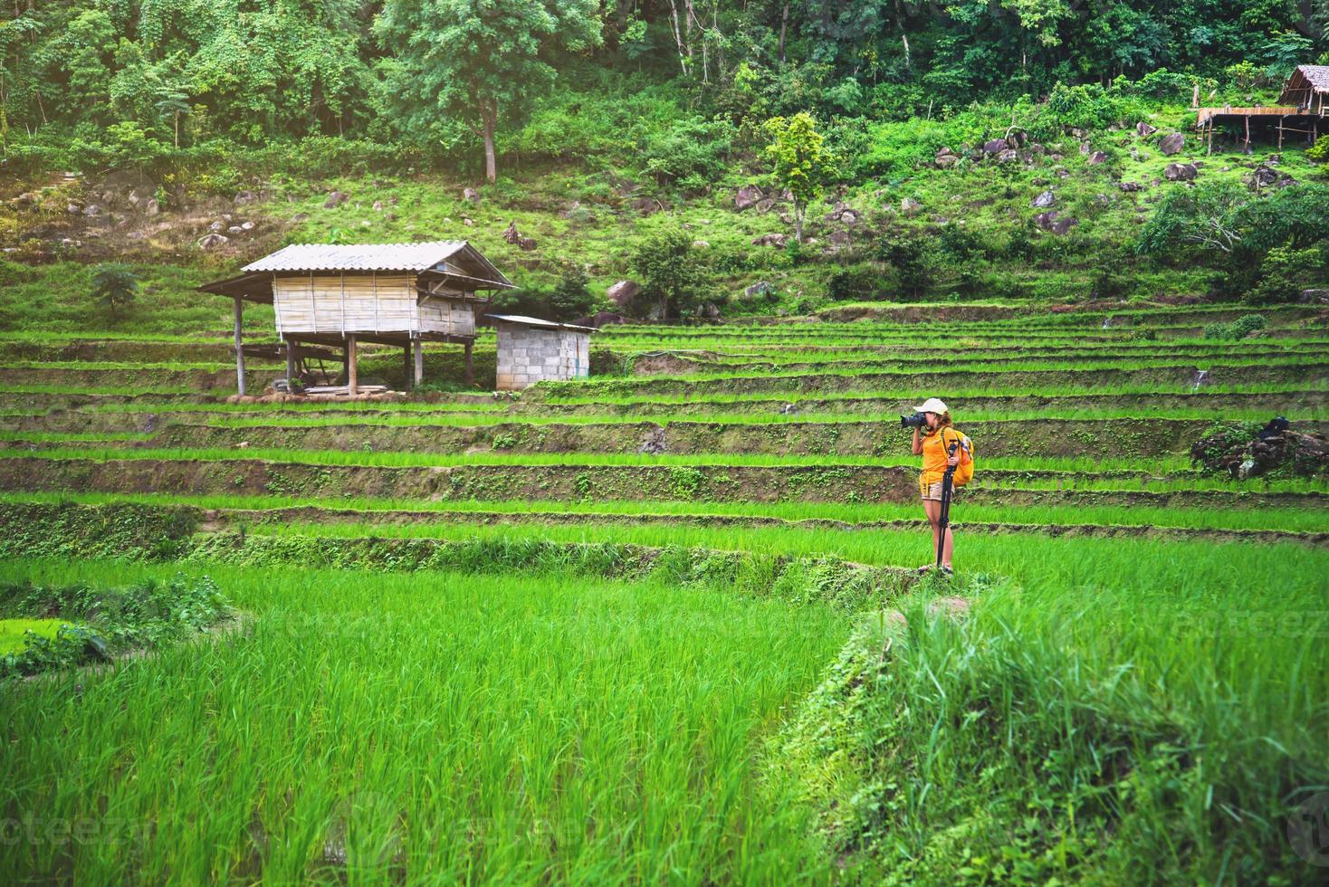 Asian woman travel nature. Travel relax. Walking take a photo on the field. in summer.