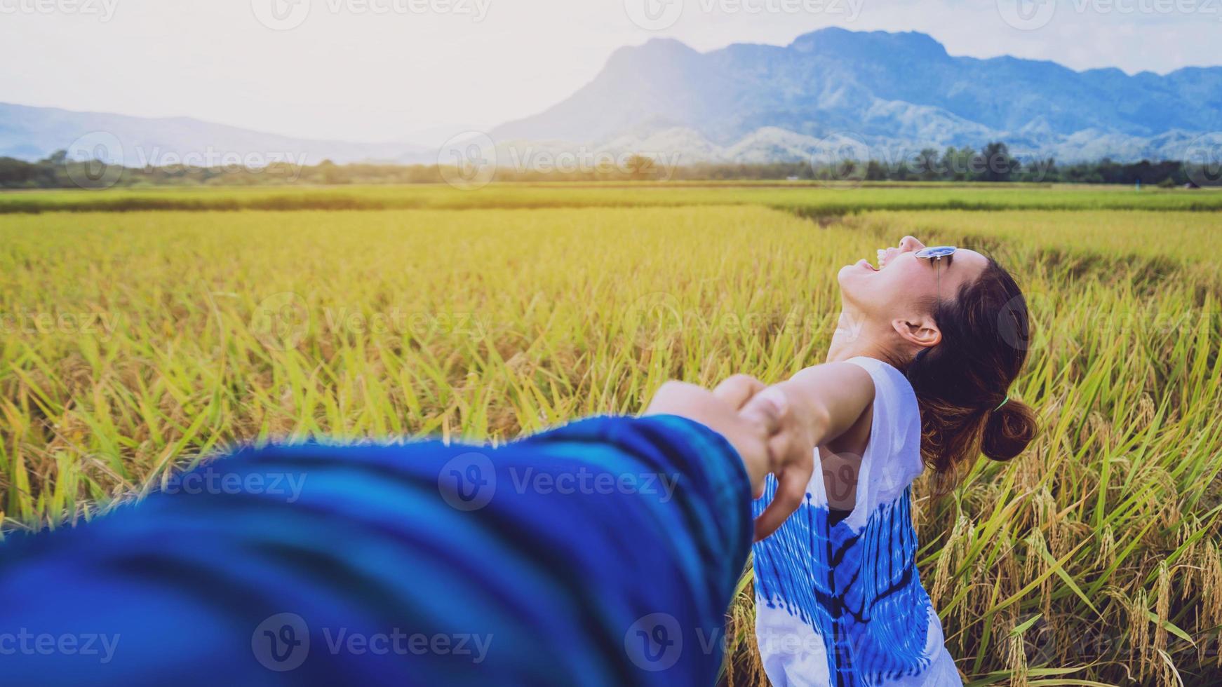 Lover women and men asians travel relax in the holiday. Lovers walk hand in hand on rice field. Thailand photo