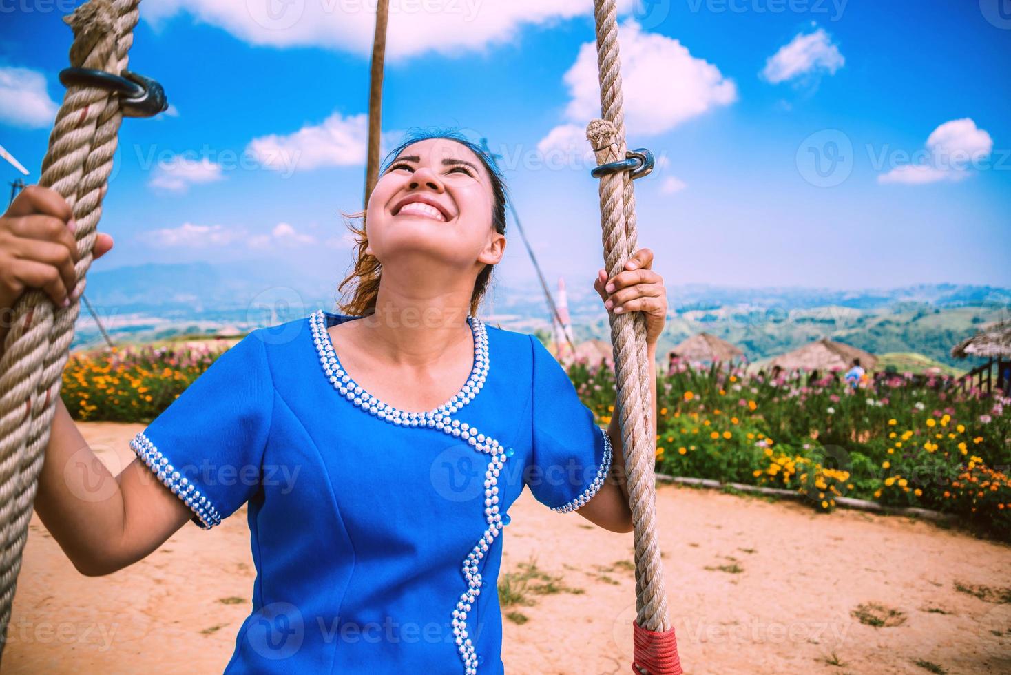 Asian women travel sleep relax. Women dress up hill tribe. women hill tribe in the field of flowers. Living swing Thailand. photo