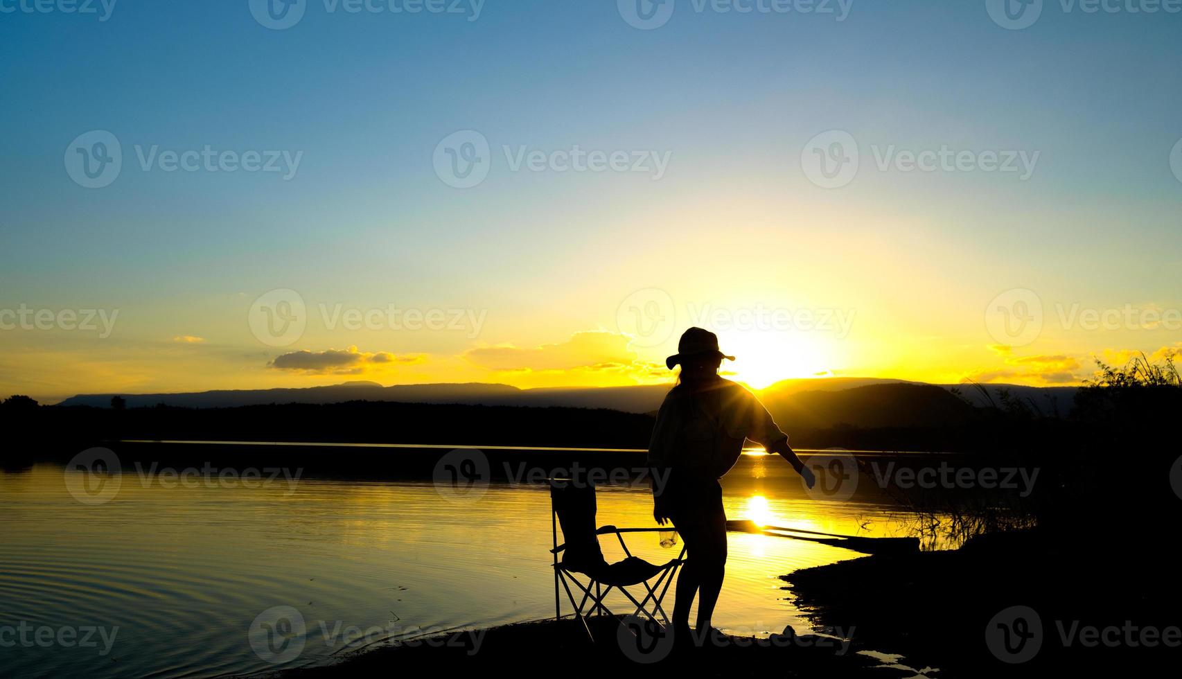 Silhouettes of women stand on the lake at sunset time, Reservoir Amphoe Wang Saphung Loei Thailand photo