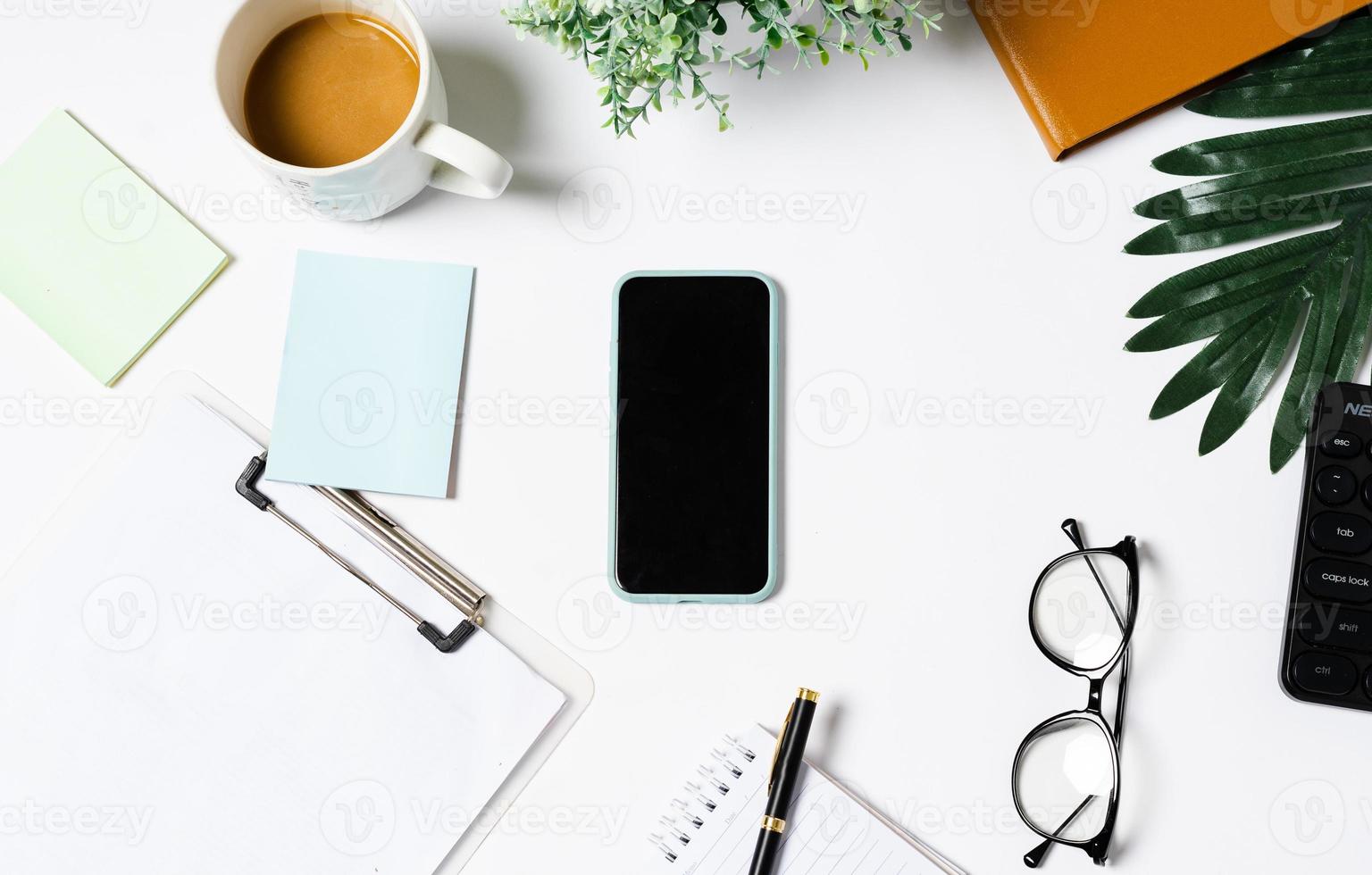 Top view of coffee, book, notebook, pen, keyboard, phone on white background photo