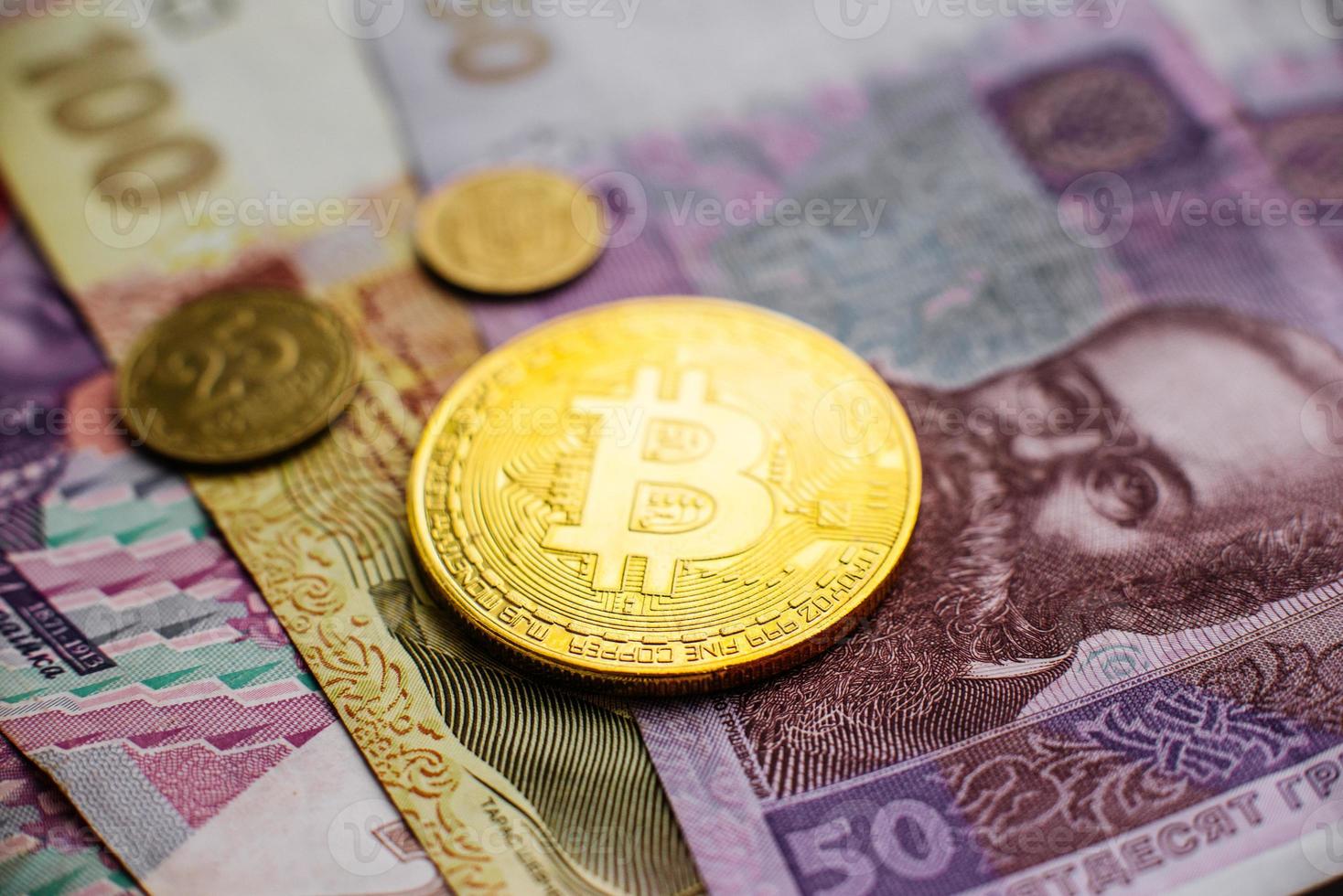 Bitcoin, Currency, digital, finance, economy. Golden bitcoin coin on hryvnia close up photo