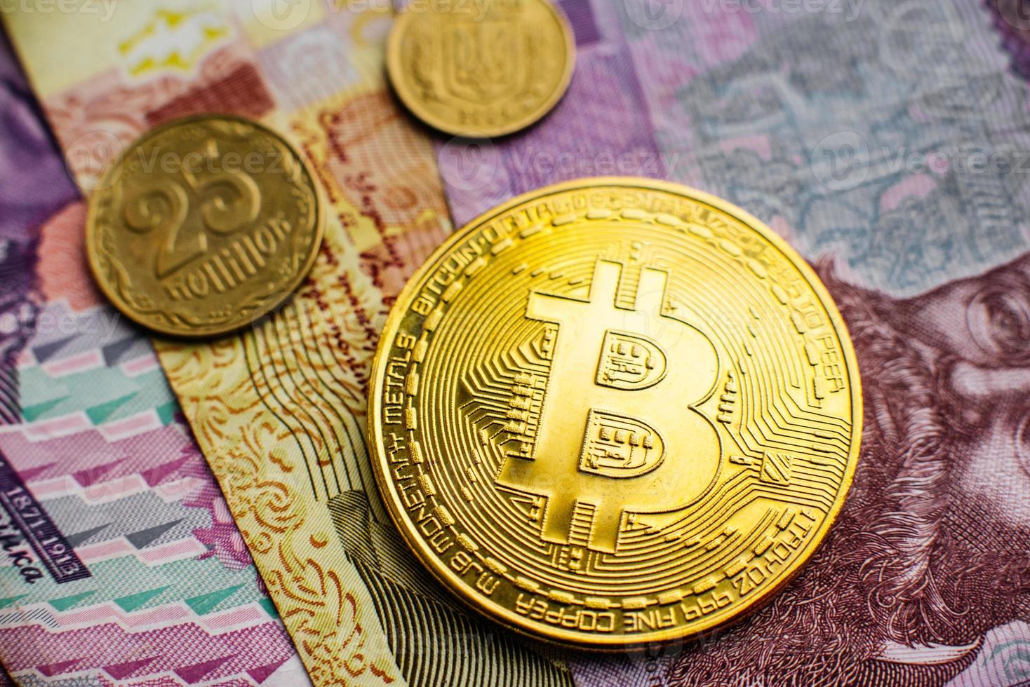 Bitcoin, Currency, digital, finance, economy. Golden bitcoin coin on hryvnia close up photo