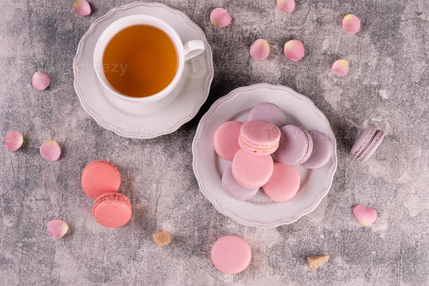 Hermosos macarrones rosados sabrosos sobre un fondo de hormigón foto