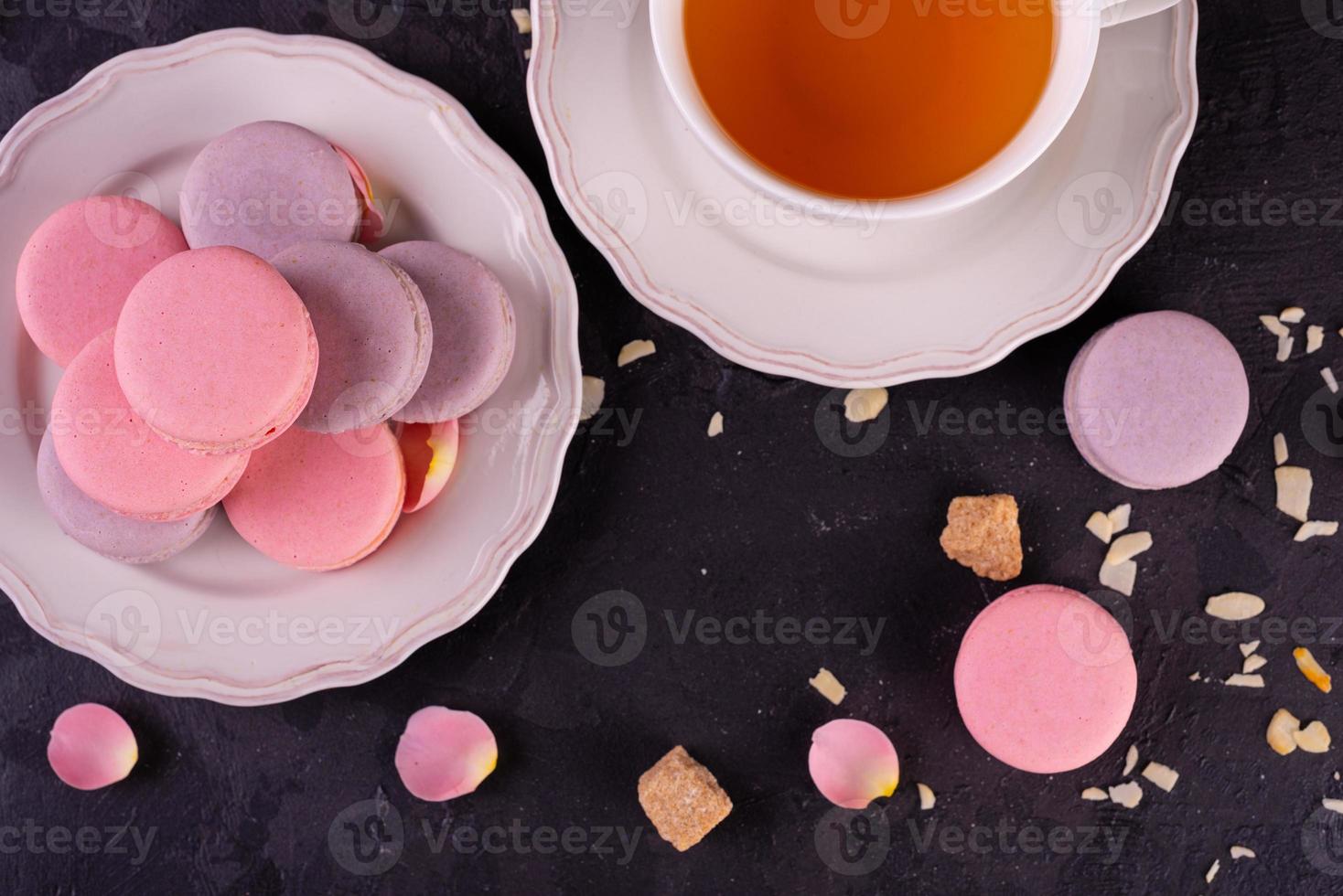 Hermosos macarrones rosados sabrosos sobre un fondo de hormigón foto