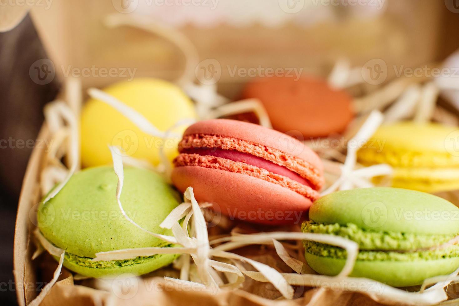 Hermosos macarrones rosados sabrosos sobre un fondo de hormigón foto