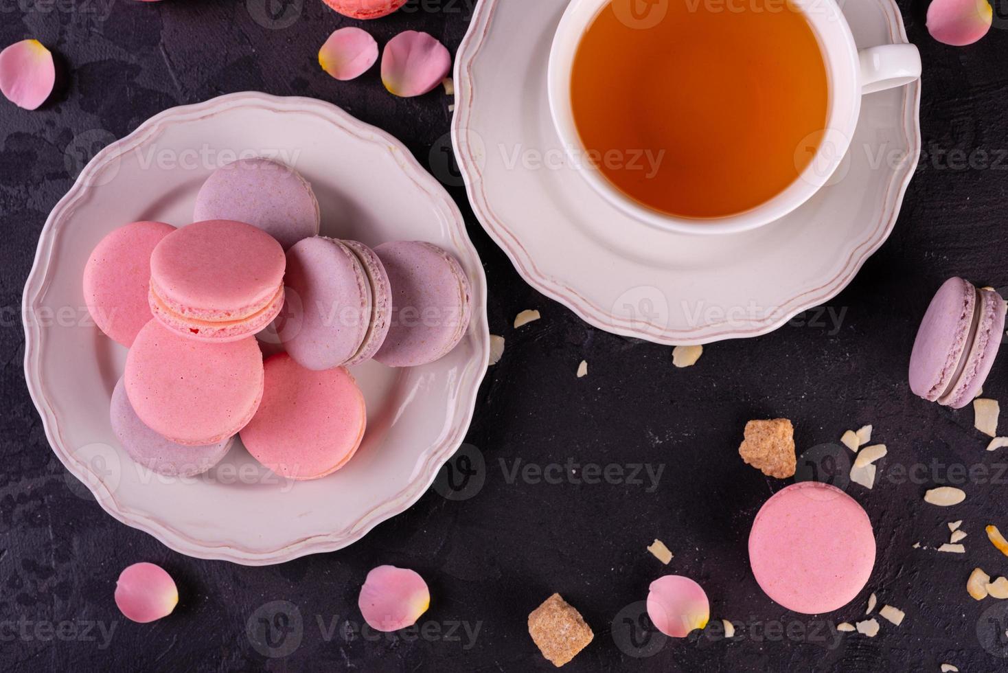 Hermosos macarrones rosados sabrosos sobre un fondo de hormigón foto