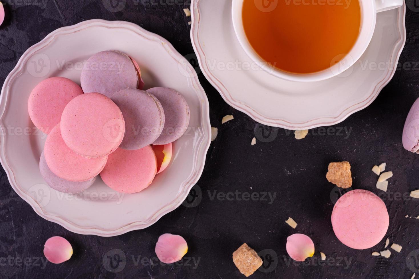 Hermosos macarrones rosados sabrosos sobre un fondo de hormigón foto