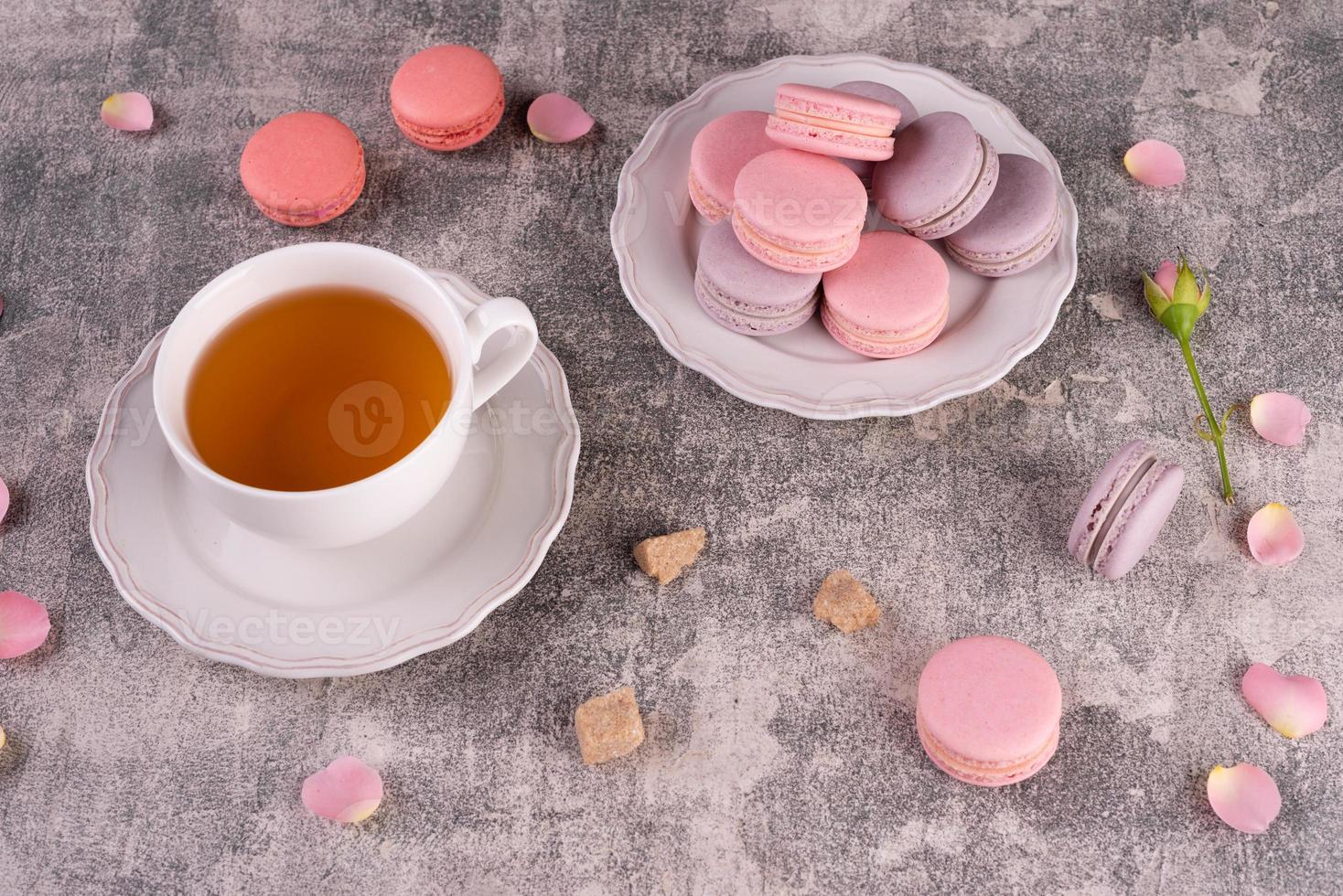 Hermosos macarrones rosados sabrosos sobre un fondo de hormigón foto