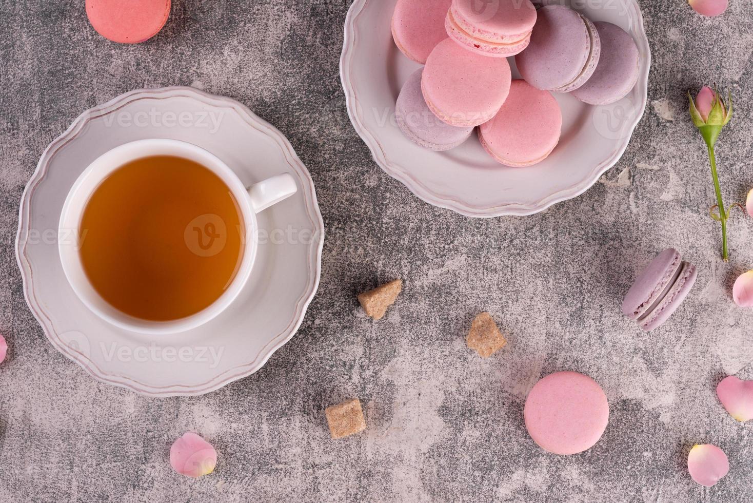 Hermosos macarrones rosados sabrosos sobre un fondo de hormigón foto