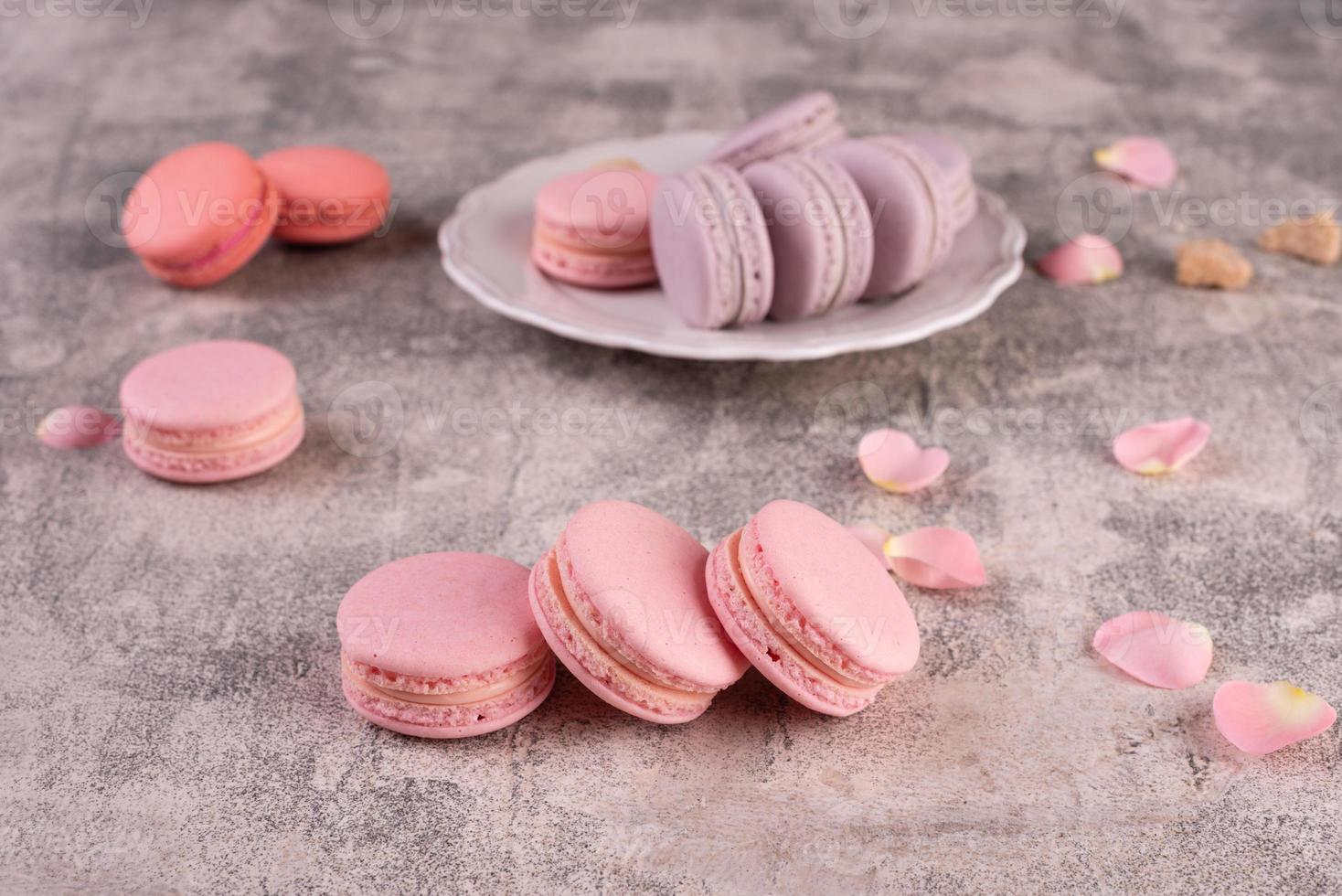 Hermosos macarrones rosados sabrosos sobre un fondo de hormigón foto