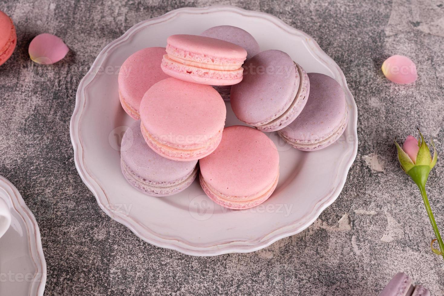 Hermosos macarrones rosados sabrosos sobre un fondo de hormigón foto