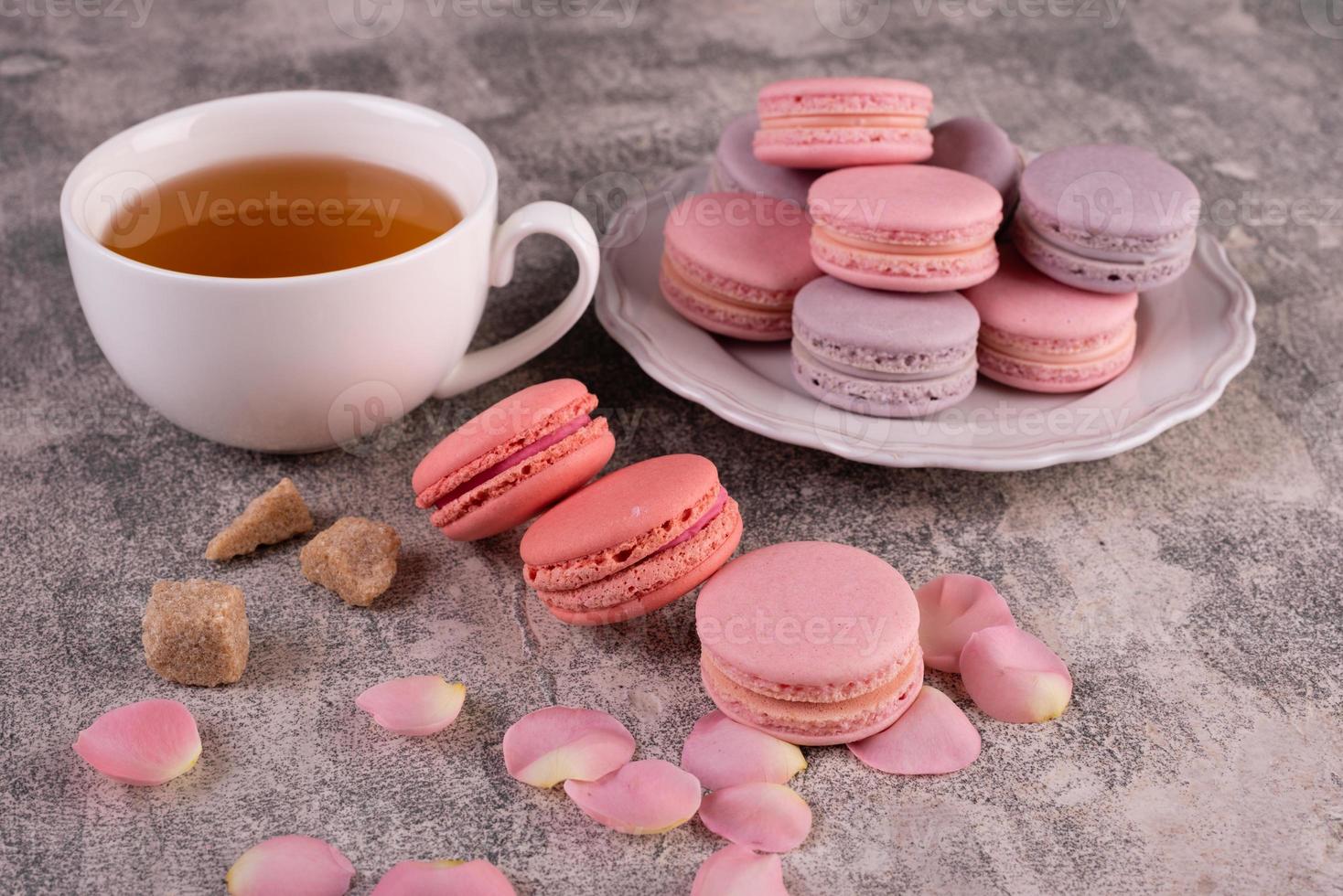 Beautiful pink tasty macaroons on a concrete background photo