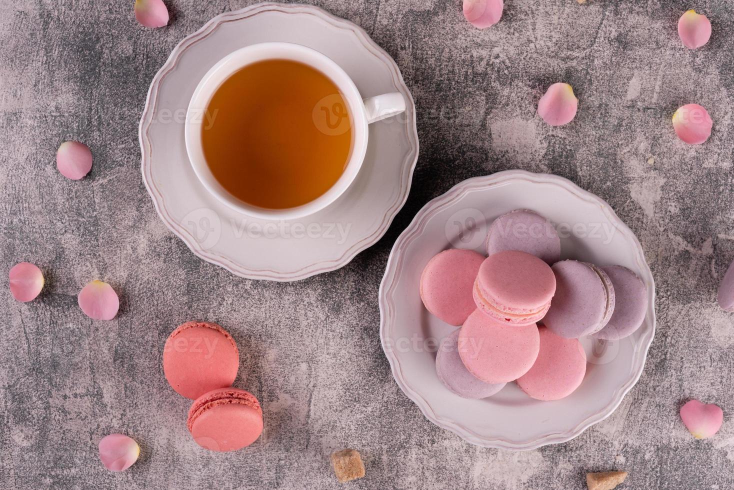 Hermosos macarrones rosados sabrosos sobre un fondo de hormigón foto