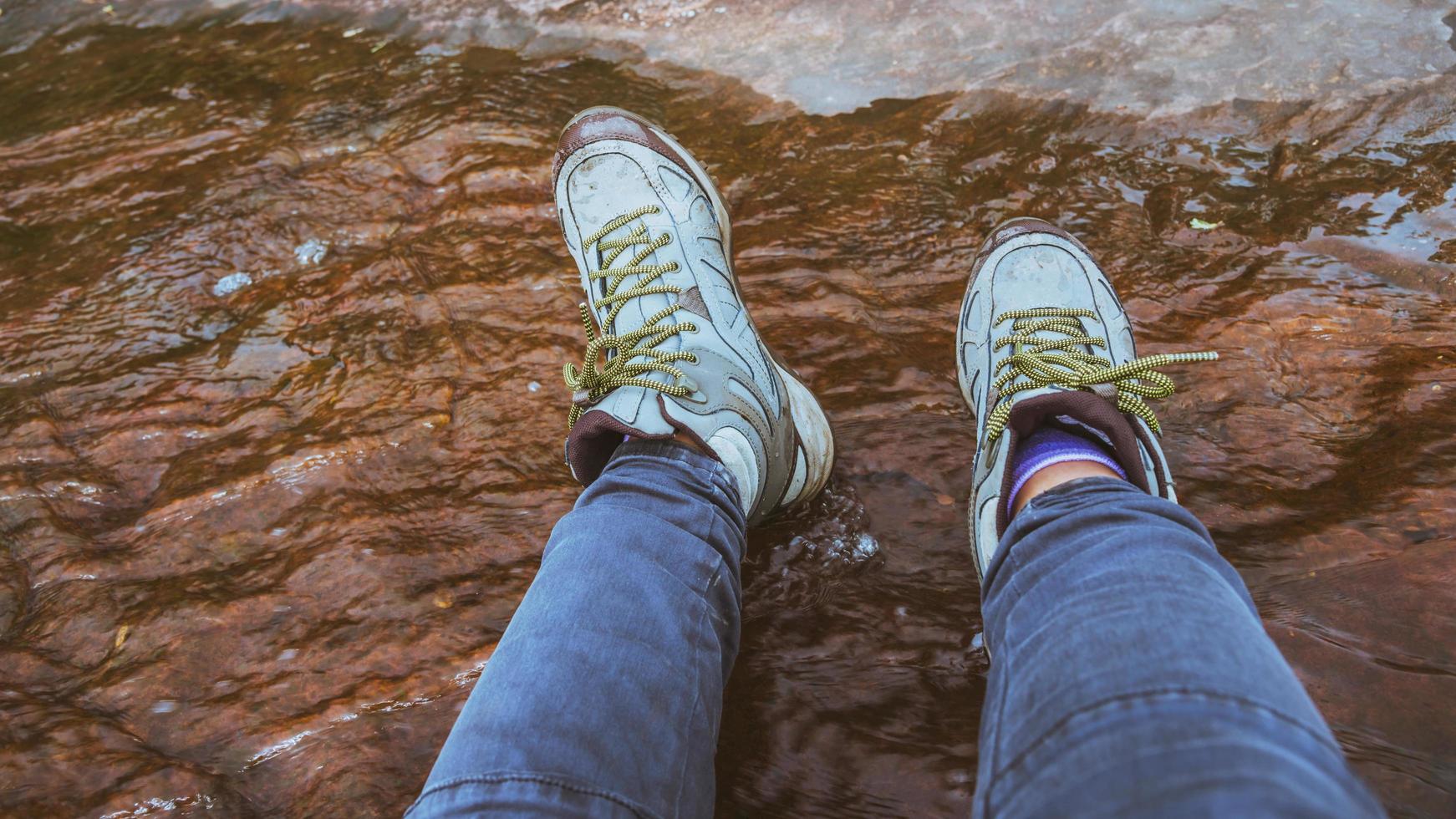 woman legs wearshoes walk in the forest wade water photo