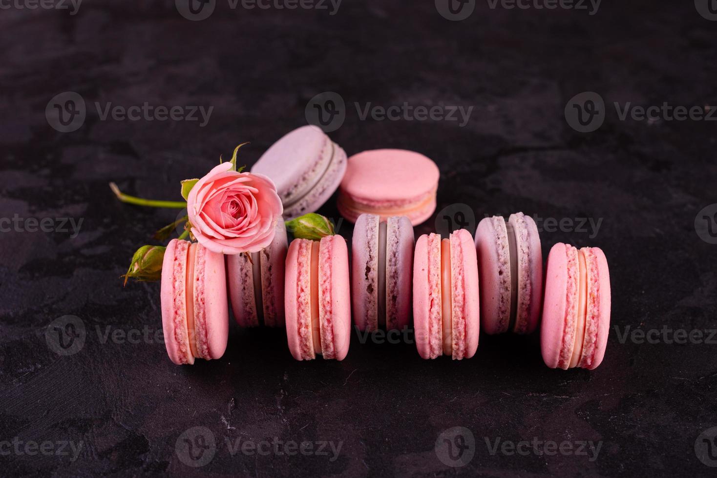 Beautiful pink tasty macaroons on a concrete background photo