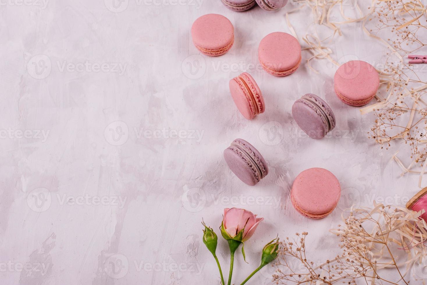 Hermosos macarrones rosados sabrosos sobre un fondo de hormigón foto