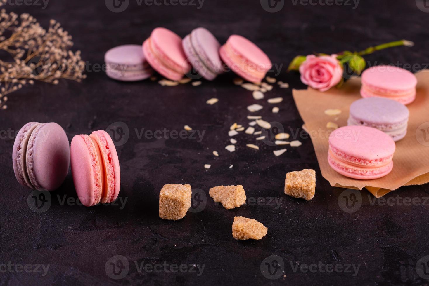 Hermosos macarrones rosados sabrosos sobre un fondo de hormigón foto